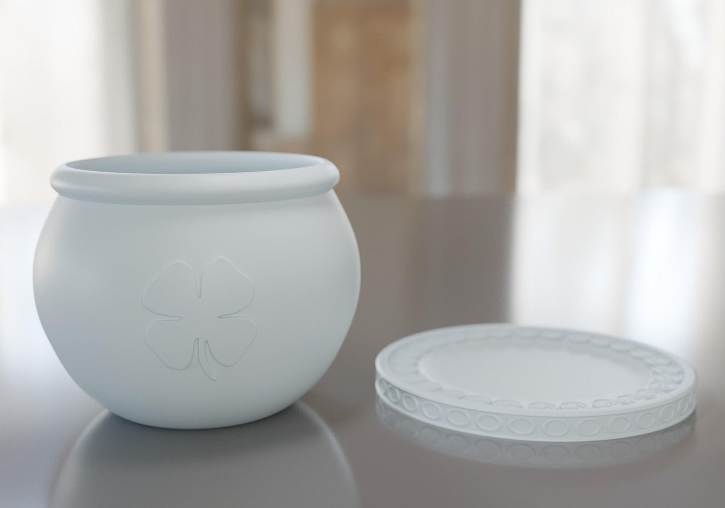 a white vase sitting on top of a table next to a white plate