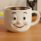 A white coffee mug with a smiling face design sits on a wooden desk, surrounded by office supplies.
