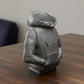 a statue of a person sitting on a table