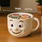 A white coffee mug with a smiling face design, filled with coffee pods labeled with different types of coffee, placed on a wooden surface.