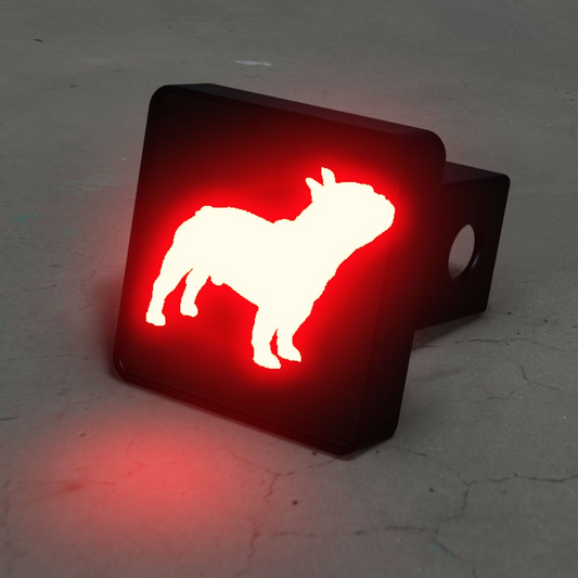 A red and white dog silhouette is displayed on a black trailer hitch.