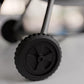 A close-up view of a black wheel with a rubber tire, likely part of a vehicle or other machinery.