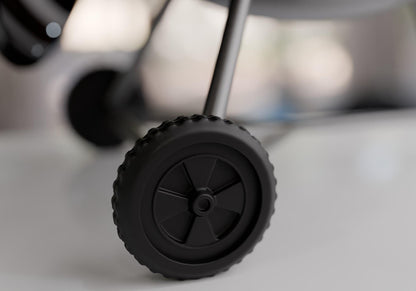 A close-up view of a black wheel with a rubber tire, likely part of a vehicle or other machinery.
