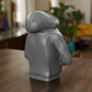 a grey lego figure sitting on top of a wooden table