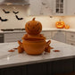 A Halloween-themed kitchen with a carved pumpkin sitting on a marble countertop, surrounded by other carved pumpkins and bats.