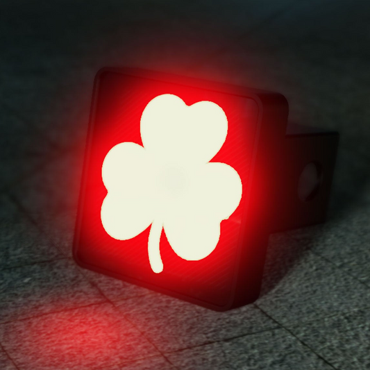 A red and white clover symbol is displayed on a trailer hitch, which is illuminated in the dark.