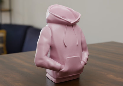 a pink statue of a person sitting at a table