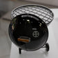 A small black barbecue grill with a metal grate and a handle on the front.