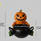 A Halloween-themed pumpkin figurine is shown sitting inside a black cauldron, with measurements provided.