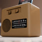A small brown radio with a speaker and dial display sits on a table.