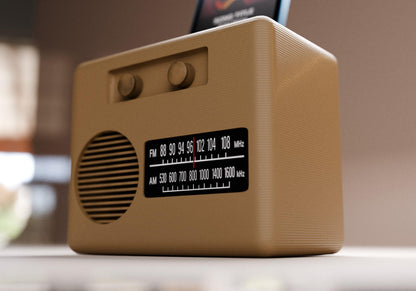 A small brown radio with a speaker and dial display sits on a table.