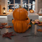 A Halloween-themed scene with a carved pumpkin, candy, and autumn leaves on a table.
