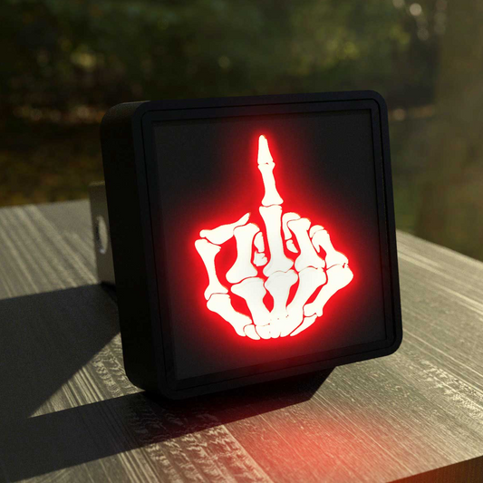 A square-shaped object with a red light on it, displaying a white skeleton hand gesture.