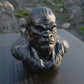 a statue of a gorilla sitting on top of a wooden table