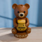 a brown teddy bear sitting on top of a wooden table