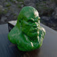 a green gorilla head sitting on top of a wooden table