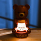 a brown teddy bear sitting on top of a wooden table