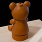 a brown bear statue sitting on top of a wooden table