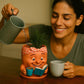 a woman pouring water into a cup next to a potted plant