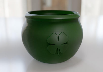 a green pot with a four leaf clover on it
