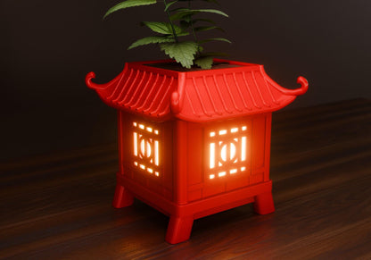 a red lantern with a plant growing out of it