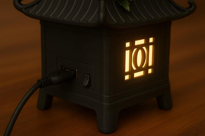 a small black lantern with a flower on top of it