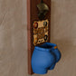 a blue pot hanging on a wall next to a sign