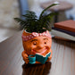 a planter with a potted plant and a book on a table