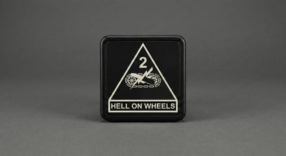 A black square sign with a white triangle and text on it, placed on a gray background.