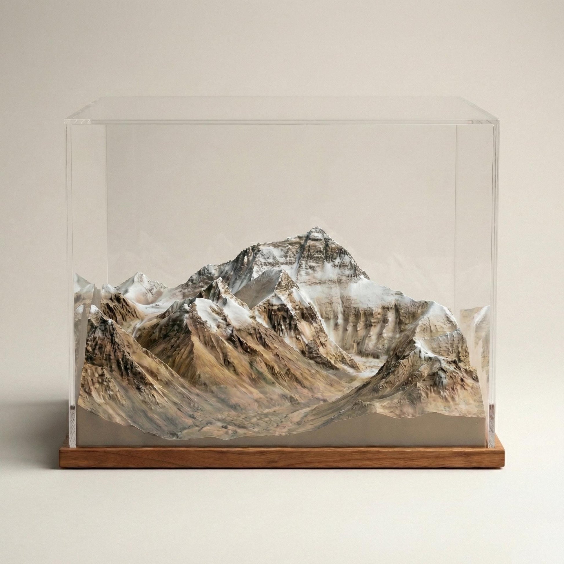 A glass display case containing a detailed model of a mountain range, with the peaks and valleys clearly visible.