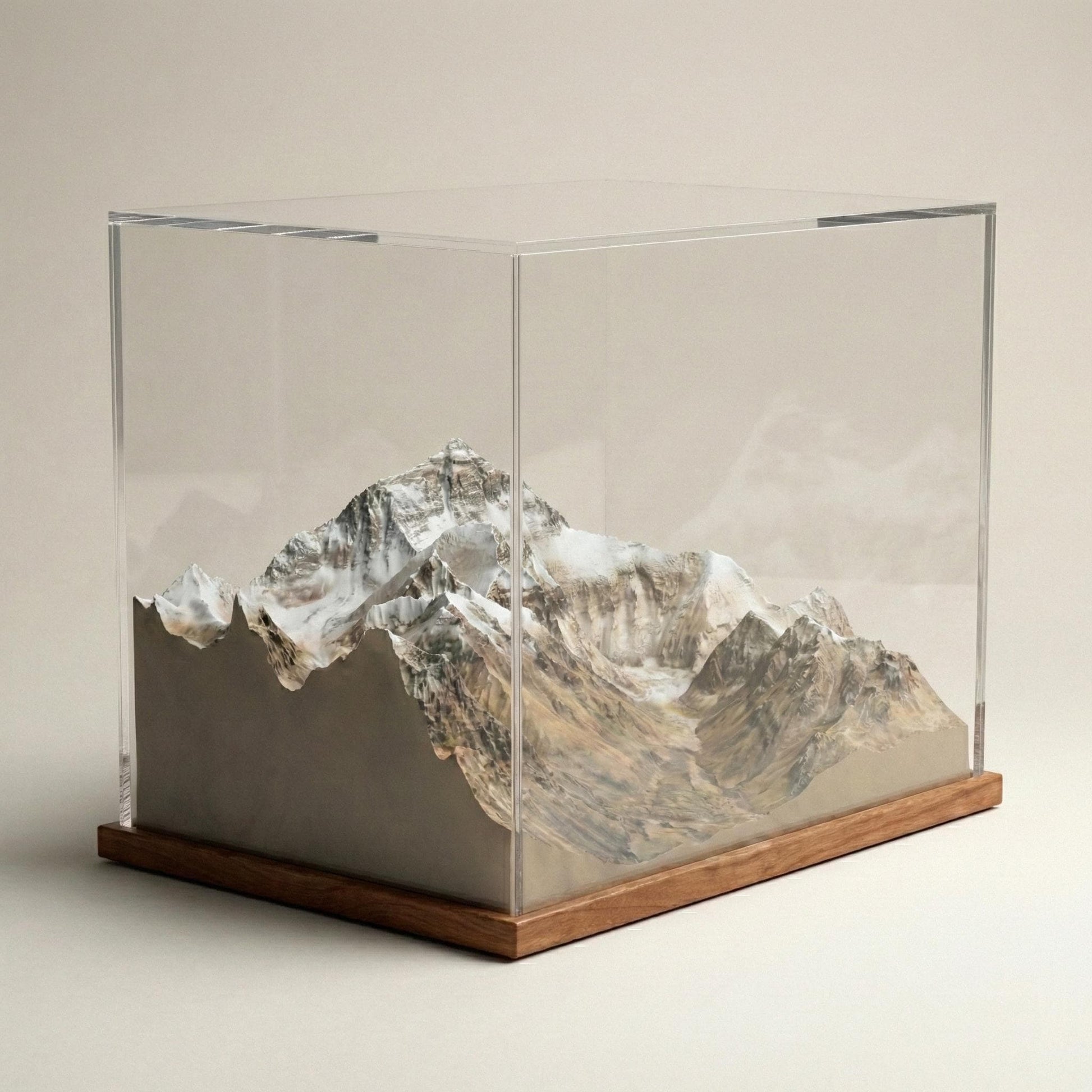 A 3D model of a mountain range displayed in a clear glass case.