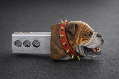 A bulldog wearing a red spiked collar is lying on a gray surface.