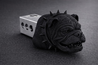 A black bulldog head with spikes is sitting on a gray surface.