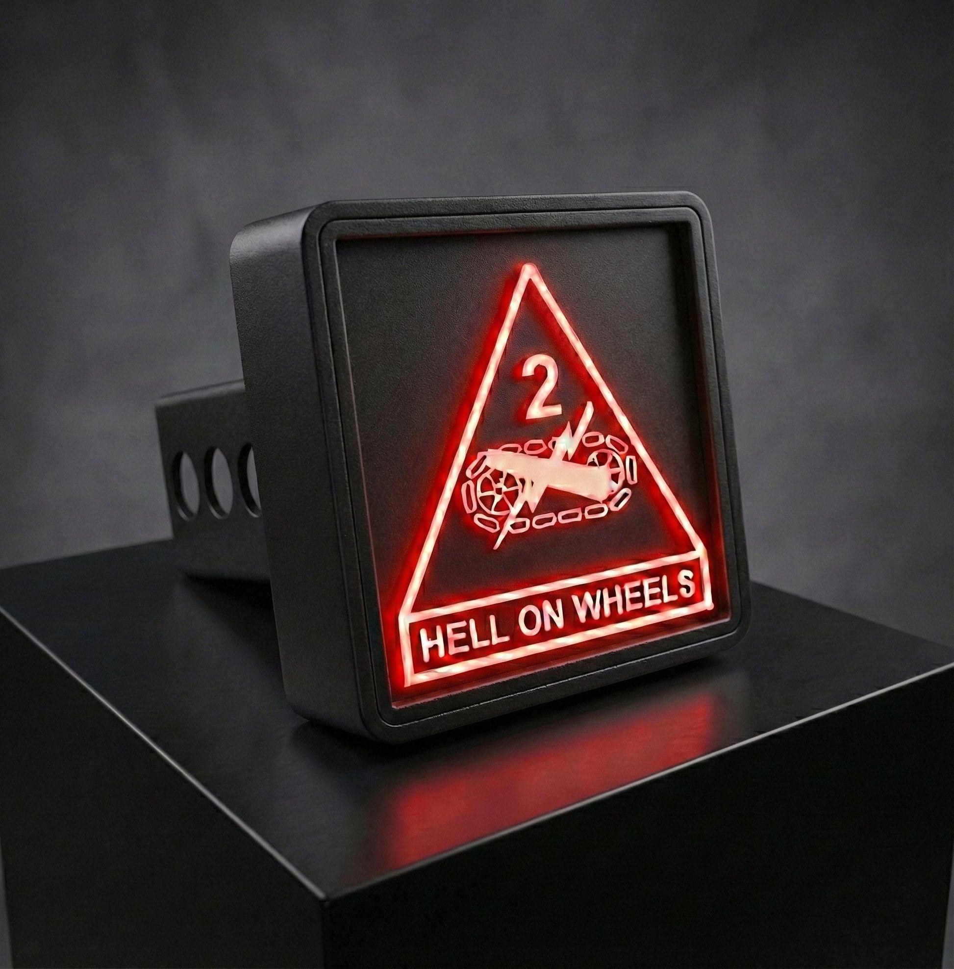 A black rectangular sign with a red triangle and the text "HELL ON WHEELS" displayed on it.