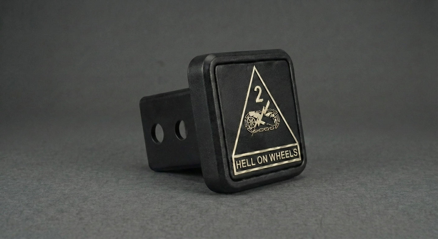 A black trailer hitch with a triangular warning sign on it, displaying the text "HELL ON WHEELS".