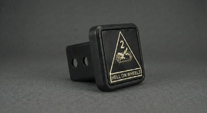 A black trailer hitch with a triangular warning sign on it, displaying the text "HELL ON WHEELS".