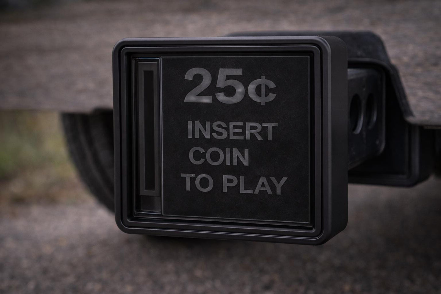 A black coin-operated slot machine with a 25¢ coin inserted, displaying instructions for playing the game.
