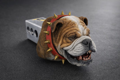 A close-up of a bulldog wearing a red spiked collar, with its mouth open and teeth bared, giving the impression of a snarling or growling expression.